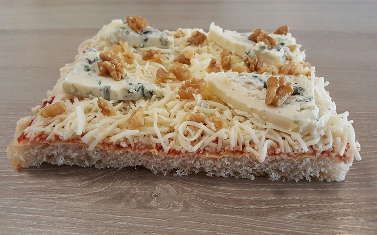 foto di una pizza verde e noci